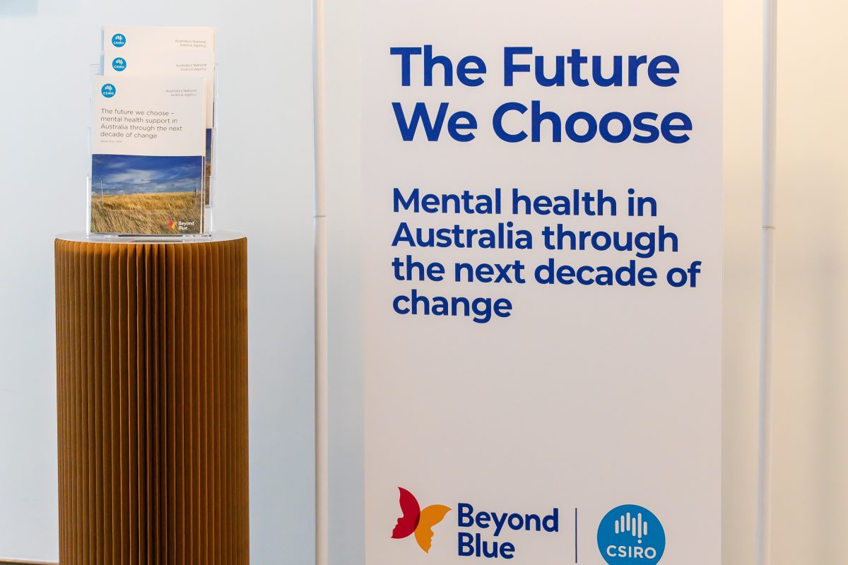 • Sign and plinth, close: The launch signage in full, the report title and subtitle above the Beyond Blue and CSIRO logos, with copies of the report displayed on the plinth alongside.