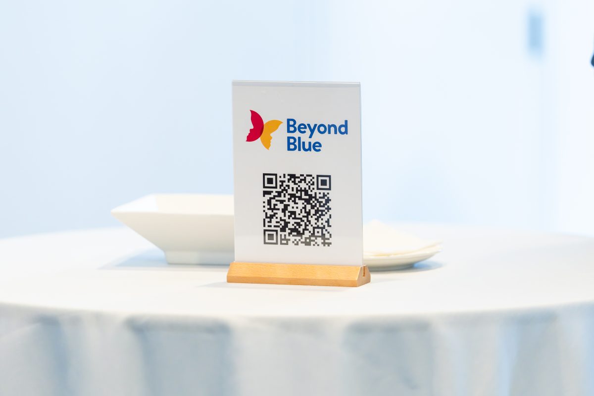 • QR table card: A Beyond Blue table card carrying a QR code, printed on acrylic in a timber base, on a white-clothed cocktail table.